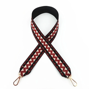 Close-up of ethnic wavy pattern fabric wide bag strap with gold metal lobster clasps