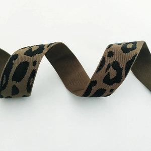 Detail of leopard print bag strap showing dense weave texture and brown leopard pattern