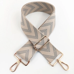 Detail of adjustable beige and grey herringbone strap with pale gold lobster clasps