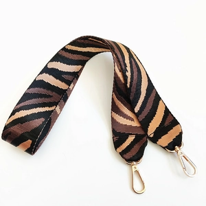 Wide zebra print shoulder strap with gold metal lobster clasps for crossbody handbags