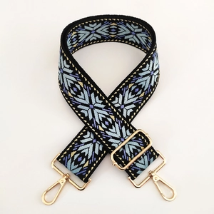 Close-up of jacquard woven strap with colorful geometric patterns and gold metal buckles