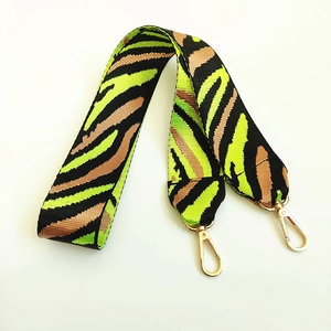 Detail of colorful zebra print nylon shoulder strap with golden metal lobster clasps