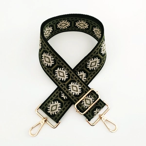 Close-up of ethnic jacquard strap with dark green geometric pattern and gold buckles