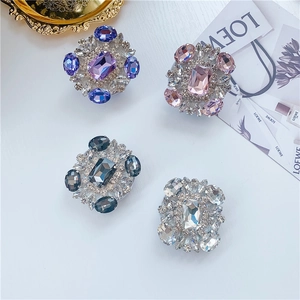 Macro detail of four crystal-encrusted rectangle cell phone grip stands in floral design