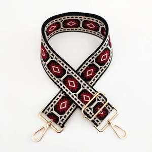 Close-up of ethnic jacquard purse strap with red and cream geometric diamond patterns