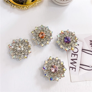 Detailed view of luxury flower-shaped rhinestone phone grips in four vibrant colors