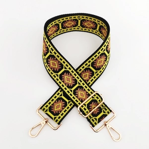 Detailed macro view of ethnic geometric jacquard bag strap with gold metal buckles
