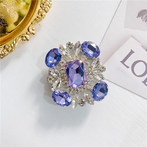 Macro view of crystal encrusted phone grip featuring purple rectangular rhinestone centerpiece
