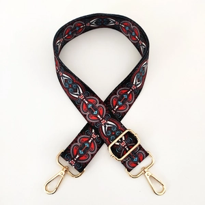 Close-up of ethnic bohemian wide purse strap with golden lobster clasps and patterns