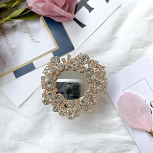 Golden rhinestone phone socket with mirror center on a white textured background