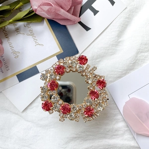 Sparkling crystal foldable phone socket with integrated mirror and red rhinestone accents