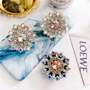 Close-up of luxury flower-shaped crystal phone sockets with rhinestone inlay on marble