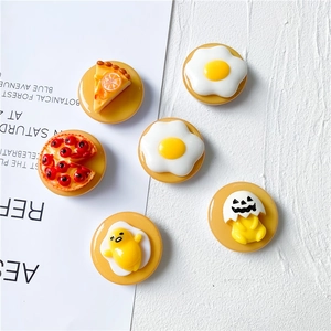 Macro detail of various resin food charms including fried egg and cake phone socket designs