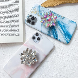 Cover di lusso effetto marmo con supporto a fiore di strass per iPhone su sfondo bianco