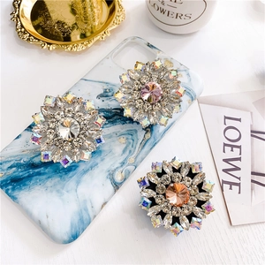 Close-up of luxury flower-shaped phone sockets with colorful rhinestones and marble case