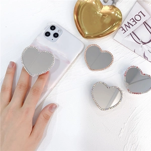 Macro shot of heart-shaped phone grip with glitter rhinestones and a mirror surface