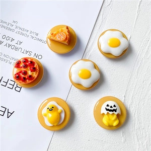 Macro shot of cartoon food phone grips featuring fried eggs and cute resin designs