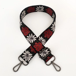 Close-up of ethnic floral print wide shoulder strap with dark metal swivel lobster clasps