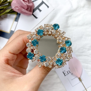 Detail of a sparkling crystal phone socket with blue rhinestones and a built-in makeup mirror