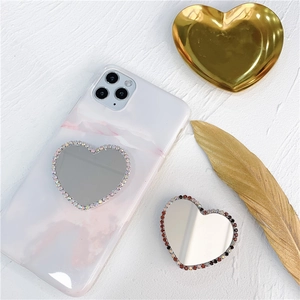 Macro shot of heart-shaped phone grip with glitter rhinestones and mirror surface