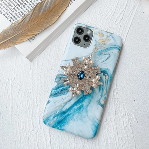 Dettaglio custodia iPhone in marmo con gioiello a fiocco di neve in perle e strass