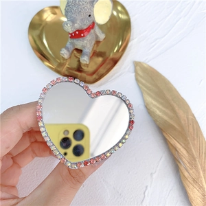 Detail of heart-shaped phone grip with sparkling rhinestones and a mirror surface