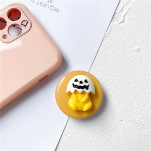 Detail of yellow round phone grip featuring 3D Halloween chick with eggshell hat