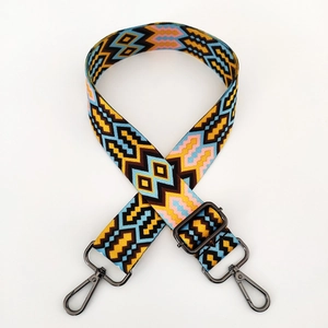 Detail view of woven geometric guitar strap with colorful patterns and metal hooks