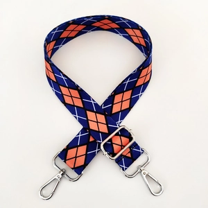 Detail of adjustable argyle pattern bag strap with polished silver lobster clasps
