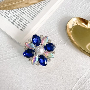 Close-up of sparkling flower phone grip with blue rhinestones and a central pearl