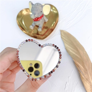 Detail of heart-shaped phone grip mirror with pink rhinestones and a reflective surface