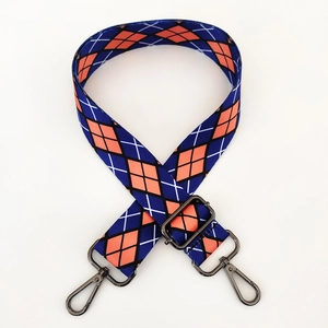 Detail of adjustable ethnic style wide bag strap with blue and orange argyle pattern