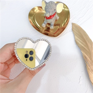 Macro detail of a heart-shaped phone mirror socket with sparkling rhinestone inlay