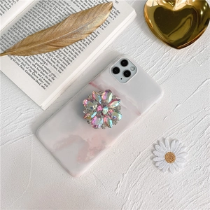 Close-up of pink marble phone case with a vibrant floral crystal rhinestone pop socket