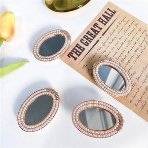 Macro detail of oval vanity mirror with vintage gold frame and pearl embellishments