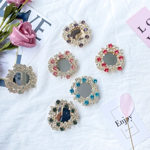 Close-up of luxury crystal rhinestone phone sockets with foldable mirror and gold frame