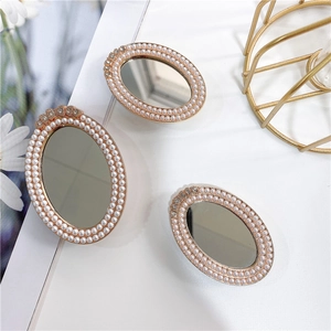 Detailed view of three rose gold oval mirrors featuring double pearl borders and rhinestones