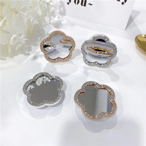 Detailed view of flower-shaped mirror phone grips with sparkling rhinestones in rose gold