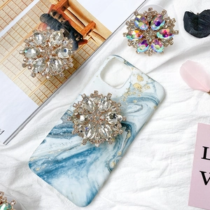 Details des luxuriösen Strass-Blumen-Handyhalters auf Marmorhülle mit Kristallen