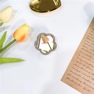 Macro shot of luxury flower phone grip with diamond crystals and round mirror center