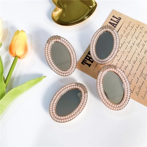 Detail of elegant pearl-encrusted mirror phone grips with sparkling rhinestones and gold base