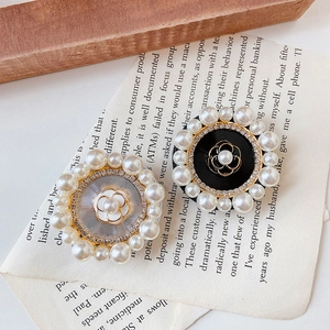 Detailed view of camellia flower phone stands with rhinestones and elegant pearls