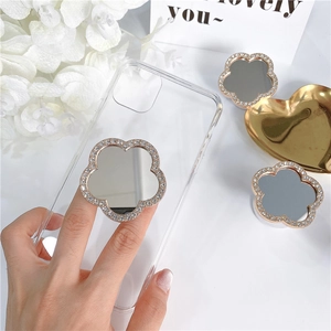 Sparkling diamond flower mirror phone socket on clear case held by a person