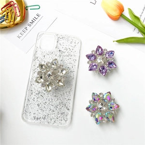 Dettaglio di supporti floreali in strass su custodie per iPhone trasparenti e glitter