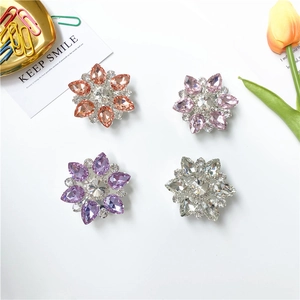 Dettaglio di quattro supporti per telefono a forma di fiore con strass colorati