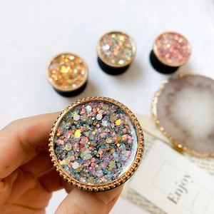 Gros plan du support de téléphone circulaire avec paillettes colorées et bordure dorée