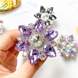 Dettaglio di un supporto per anello per telefono a forma di fiore con cristalli viola e strass