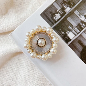 Detailed macro view of luxury pearl phone socket with rhinestone circle and sunburst pattern