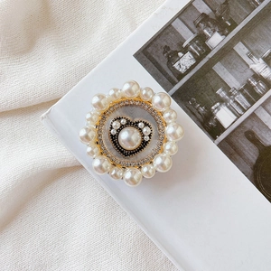 Detail of a gold heart phone socket with elegant faux pearl border on white fabric
