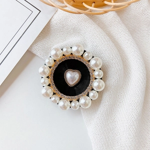 Detail of elegant black phone socket with rhinestone circles and pearl heart ornament
